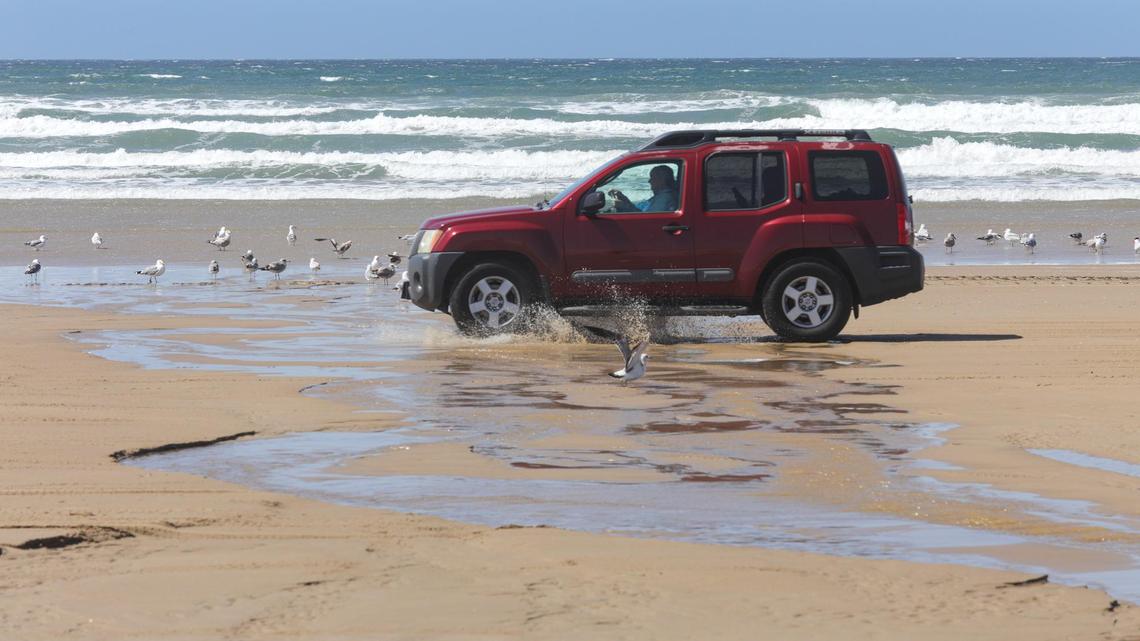 Cars cross Arroyo Grande Creek as it flows to the Pacific Ocean at Oceano Dunes SRVA on March 22, 2021. A new agreement in December 2021 temporarily lifts a restriction preventing vehicles from crossing the creek any time it’s flowing to the ocean. Now, cars will be allows cars to cross as long as the water is no more than 12 inches deep. The Coastal Commission had voted to ban vehicle crossings of the creek if any amount of water flowed into the ocean.