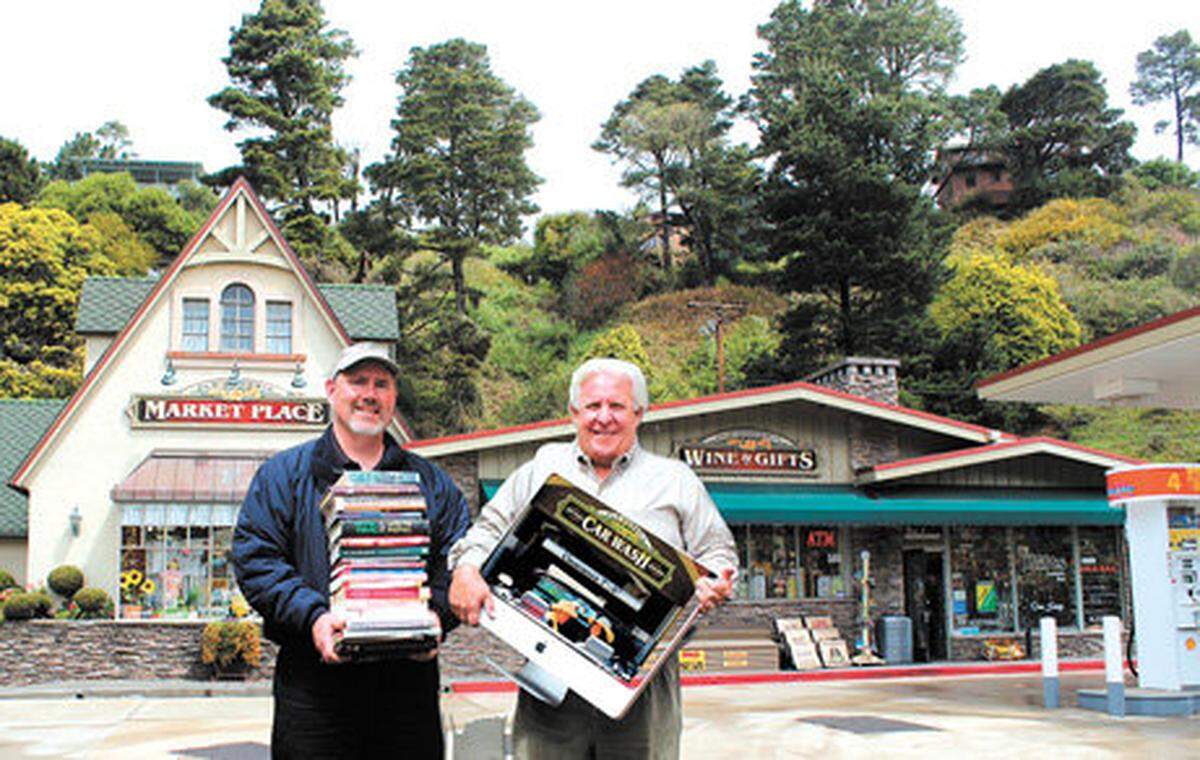 Old Cambria Market Place and Car Wash coowners Eric Johnson, holding books, and John Hallvik, holding a computer.