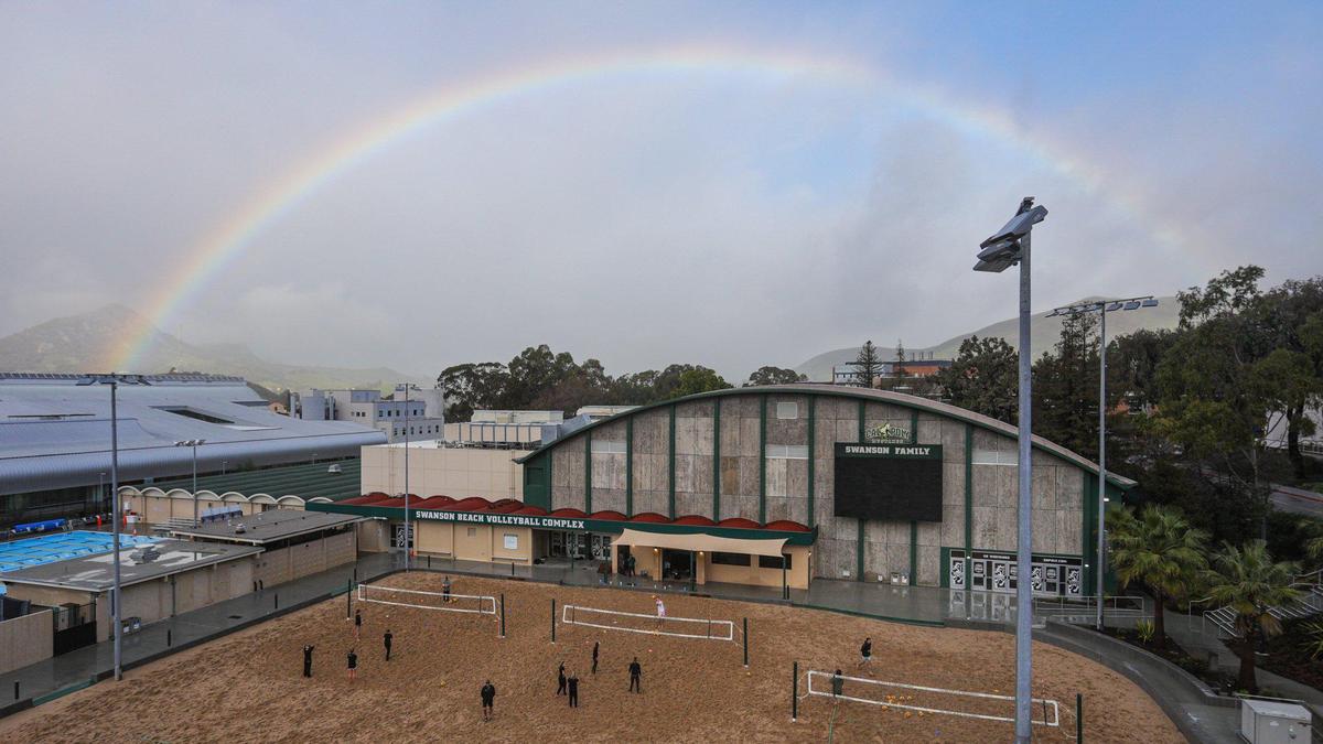 Rainbow arches over the Mott Athletics Center and beach volleyball courts at Cal Poly. Storm updates Jan 16, 2023, as a series of atmospheric river storms hit the coast.