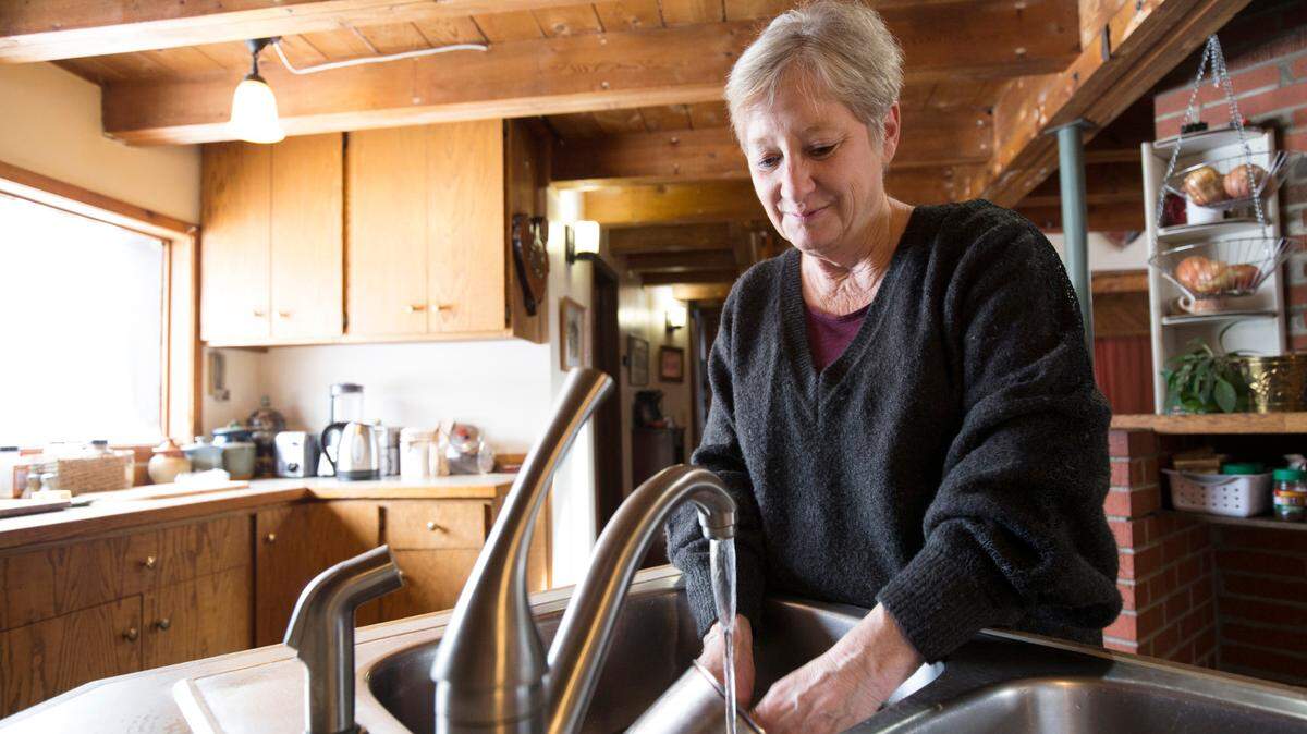 Catherine Maynard, a natural resource analyst for the U.S. Department of Agriculture, washes dishes in her home in Rimini, Montana, in 2019. What’s the best way to save water?