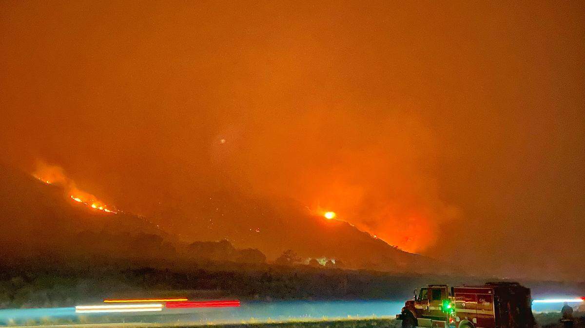 A CalFire engine keeps an eye on fire activity while parked in the center divider of Highway 101.