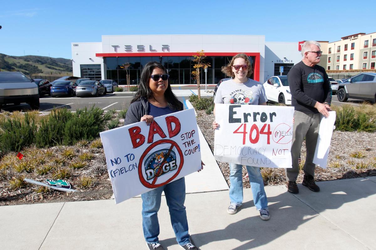 Dozens of people demonstrated outside the Tesla dealership in San Luis Obispo on Saturday, Feb. 8, 2025. They eventually walked from Calle Joaquin to Los Osos Valley Road.