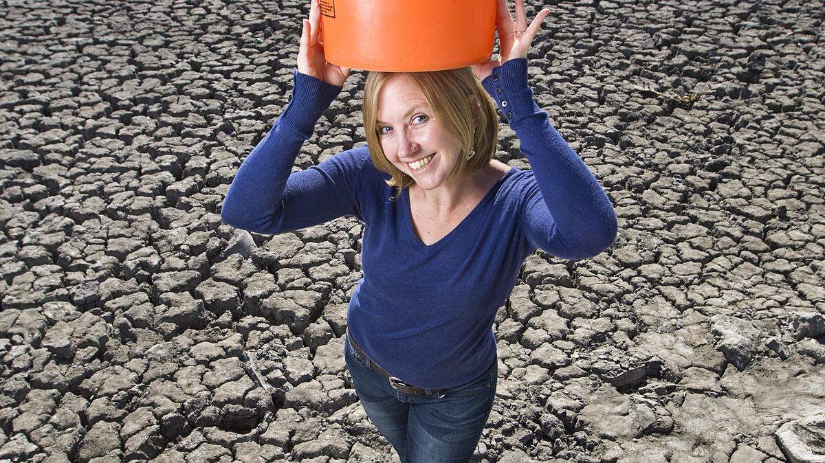 Brittany App stands in the dried-up Atascadero Lake on Tuesday, Aug. 26, 2014, holding a five-gallon water bucket that she used as part of her Five Gallon Challenge. 