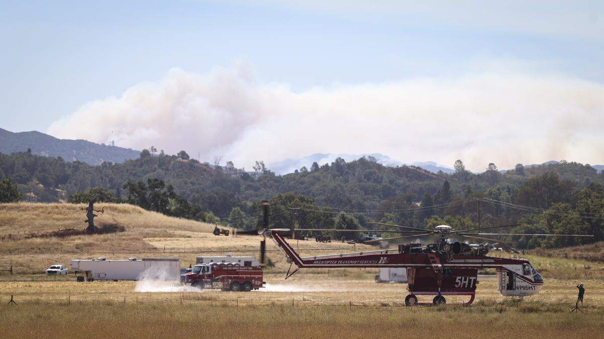 Helicopters prepared to take off from the Santa Margarita Ranch fire camp as smoke from the Gifford Fire billowed in the sky on Aug. 13, 2025.
