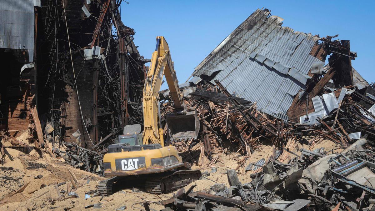 Grain and charred timbers spill from fire damaged silos as demolition work continued of the landmark Templeton Feed & Grain building on July 7, 2025. The historic building burned in a fire that sparked in the late night hours of July 4.