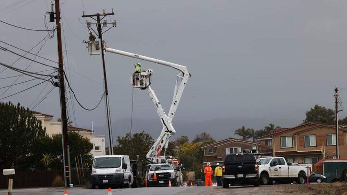 A utility crew works on damaged power lines near 13th Street and Highland Way during winter storm conditions.