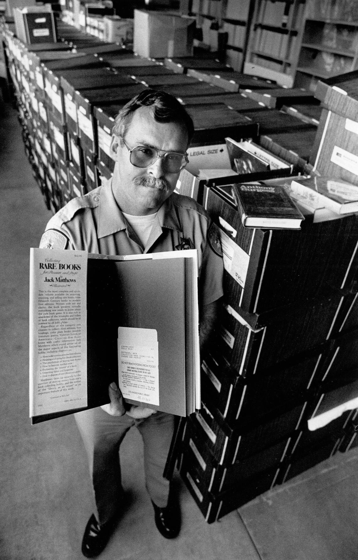 Cal Poly officer Mike Kennedy holds book â€” titled ‘Collecting Rare Books for Pleasure and Profit’ â€” one of the 10,000 found in a raid on a shed of Oscar nominee Jerry G. Hasford. David Middlecamp Published 3-18-1988