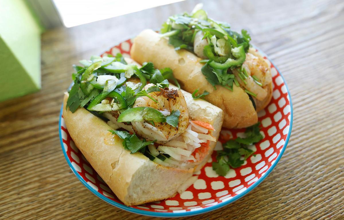 The banh mi sandwich is made with a Vietnamese baguette, rice vinegar and pickled carrot, daikan, cucumber, cilantro, jalapenos, maggai and red curry remoulade. The added protein is grilled shrimp.