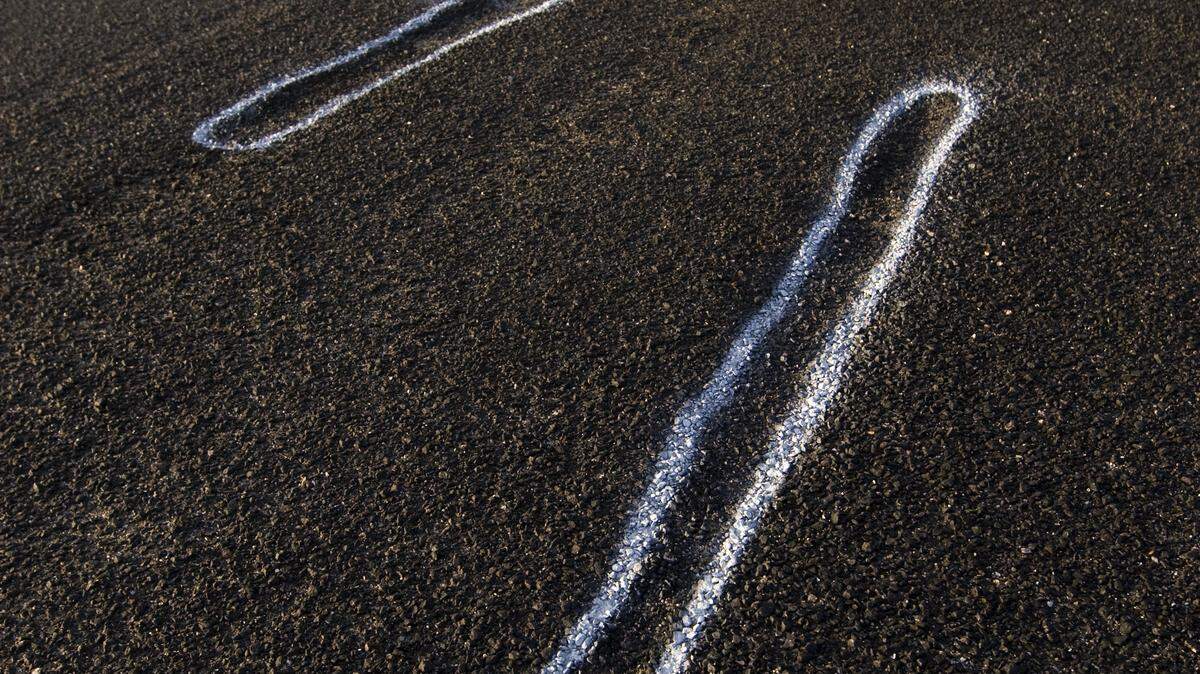 Potholes, some several inches deep, are seen outlined in the bike lane after having been camouflaged by the repaving.