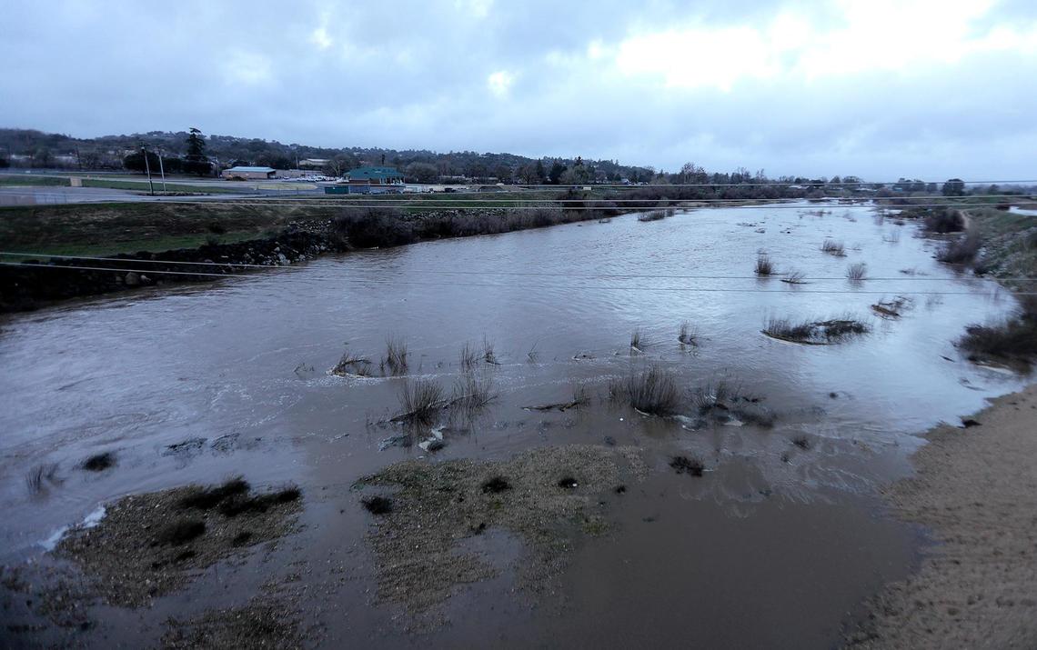 A swollen Salinas River flows under the Highway 41 bridge, east of Atascadero, on Thursday, Jan. 5, 2023, the morning after a “bomb cyclone” storm hit San Luis Obispo County.