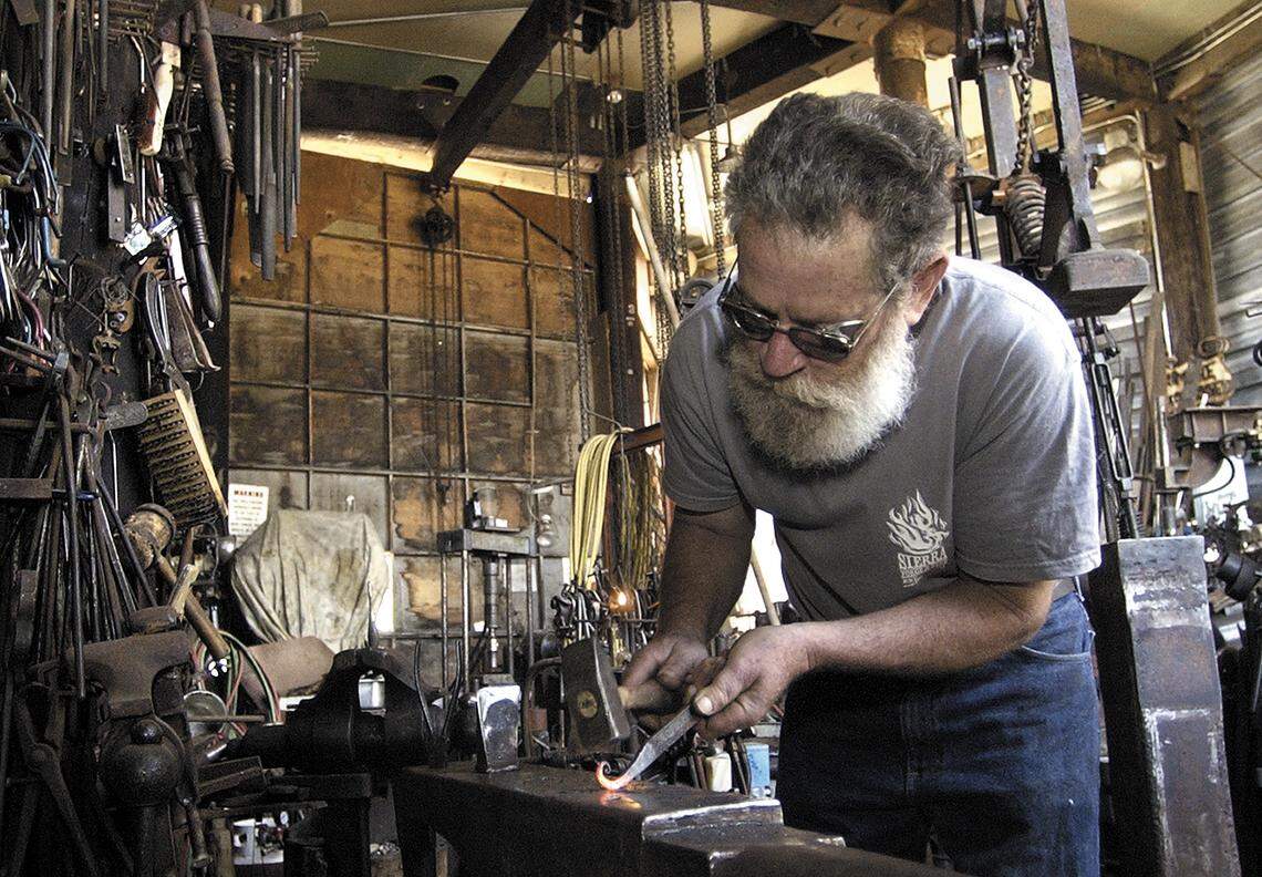 Big Sur sculptor Peter Fels shapes a piece of metal into a spiral in his shop off Highway 1 in 2004. Fels, who lives on the southern Big Sur coast, injured his neck in a car crash on Dec. 30, 2022, and was taken by helicopter to a San Luis Obispo hospital for treatment.
