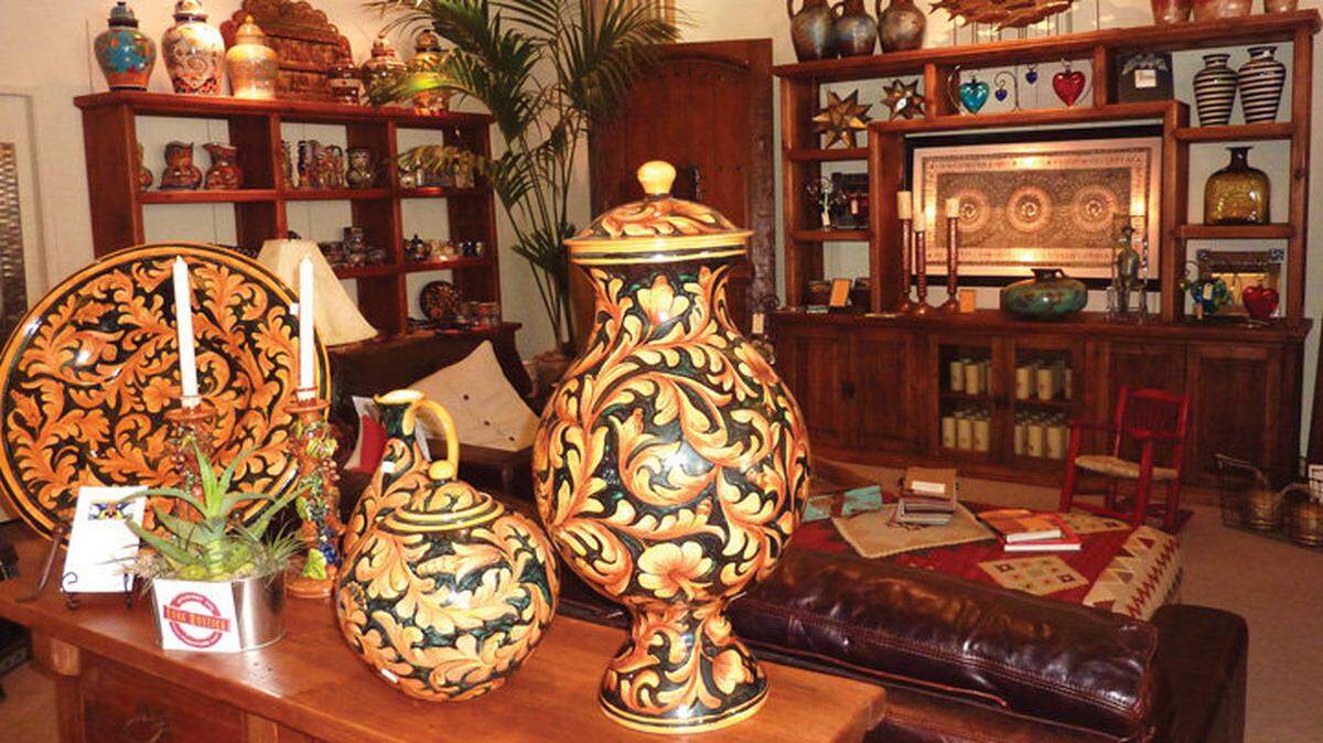 Talavera pottery is prominently displayed in front of a custom media cabinet adorned by lighted wall art at Luna Rustica’s warehouse showroom, with hand-selected pottery and artisan-made wares reflecting the different crafts of Mexico.