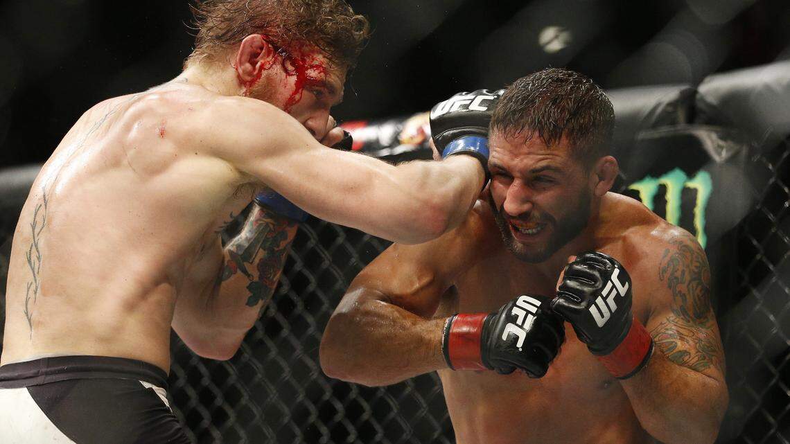Conor McGregor, left, hits Chad Mendes during their interim featherweight title mixed martial arts bout at UFC 189 on Saturday in Las Vegas.