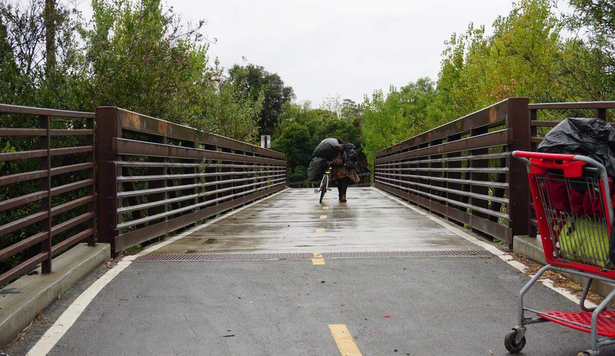 A former resident of a homeless encampment walks down the Bob Jones Trail away from the encampment after it was cleared by the city of San Luis Obispo on Monday, Sept. 19, 2022.