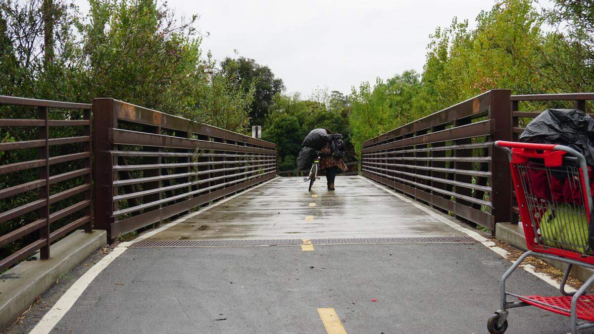 A former resident of a homeless encampment walks down the Bob Jones Trail away from the encampment after it was cleared by the city of San Luis Obispo on Monday, Sept. 19, 2022.