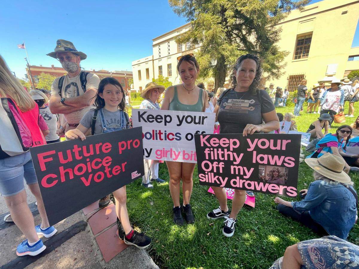 From left, daughters Afina Segler and Zahira Segler and mother Brooke Segler, attending the Planned Parenthood rally and march on Saturday, May 14, 2022.
