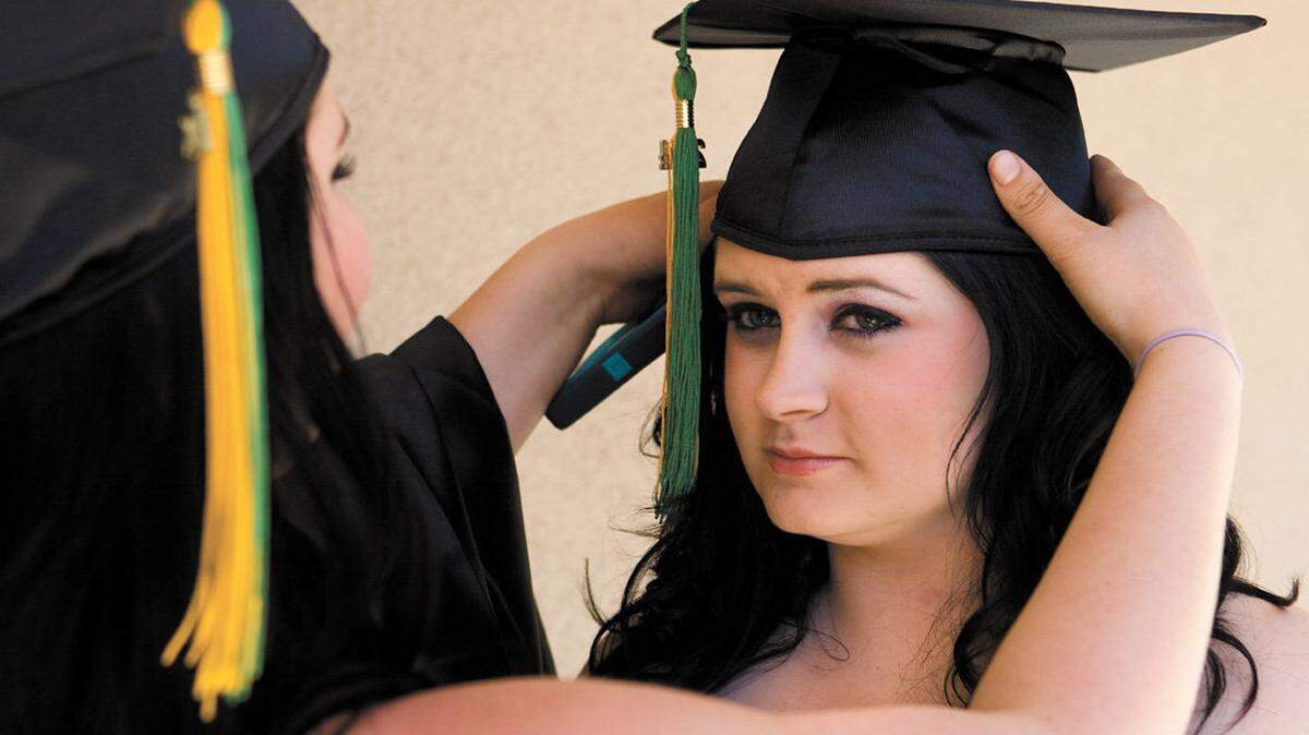 Jacey Behl, left, and Keeley Buehre get ready for the Pacific Beach High School graduation ceremony Thursday, June 5, 2014.