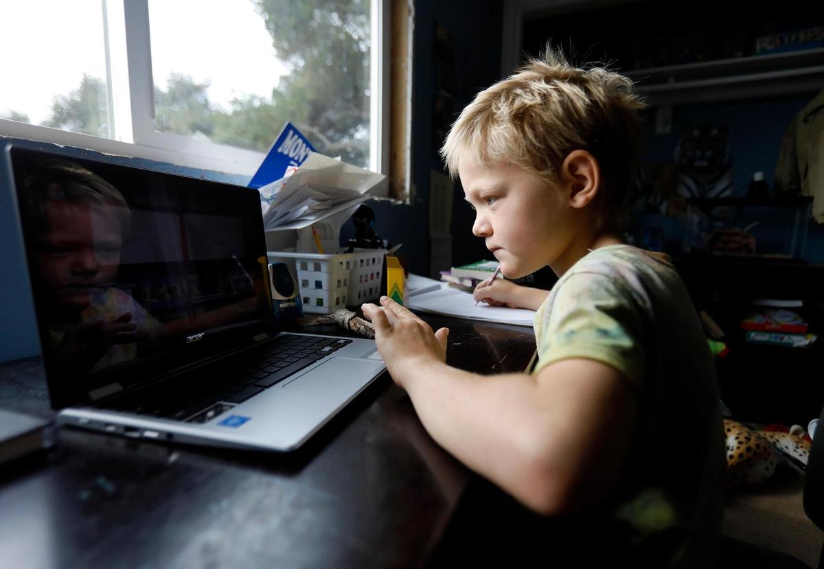 Nolan Keiper, 8, listens to drawing instructions on his laptop while distance learning with the Atascadero Unified School District.