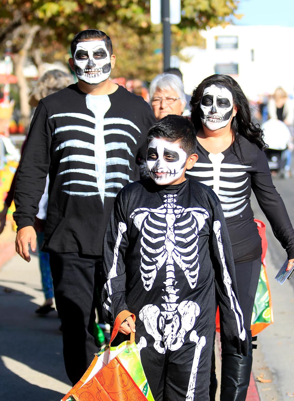 Aiden Garcia, 9, front, trick-or-treats in the Village of Arroyo Grande with his his mother, Maria Garcia, left and his dad Richard Garcia, rear, in 2019.