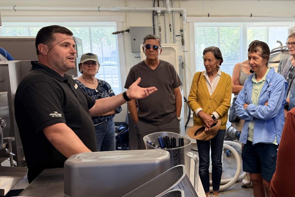 Visitors wearing protective hairnets gather around Leo Leo Gelato co-founder Niccolo Lekai during a tour of the company’s Paso Robles production facility during Open Farm Days Weekend on June 20, 2026. Guests learned about ingredient sourcing, production methods and the gelato-making process while touring the factory.