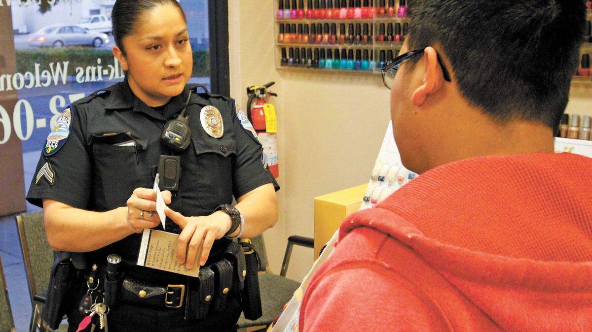 Senior Grover Beach police Officer Nelida Aceves, working the night shift, talks to Quan Do about a theft investigation Wednesday. Aceves is one of four Hispanic officers in the city, where Hispanic residents make up nearly a quarter of the population.