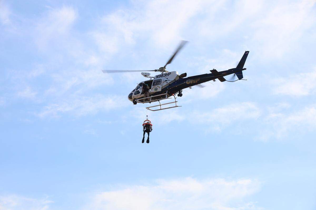 Divers were lowered into the water to examine an overturned boat off the coast of Cayucos on Oct., 25, 2024. 