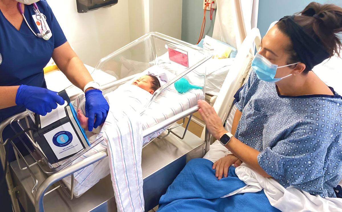 Kelsey Bilsten looks at her daughter, Blake Charlotte Bilsten, get her footprint scanned with CertaScan. Blake was the first baby born in the county in 2022.
