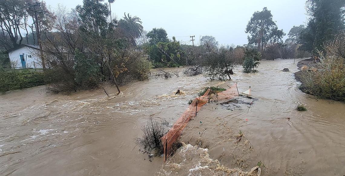 The creek from a flood Laguna Lake is raging along homes of Oceanaire Drive south of Froom Ranch Way bridge.