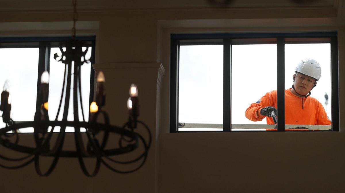 Baldwin Garcia puts finish paint on a mezzanine window on Sept. 16, 2023 as the renovation of the Anderson Hotel Apartments neared completion, on Sept. 16, 2024.