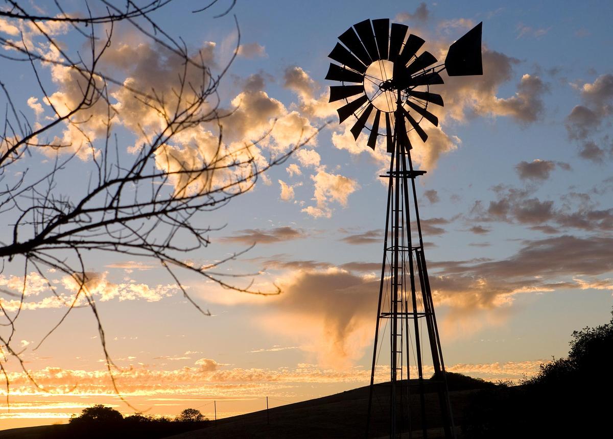 A windmill stands against incoming clouds and the sunset along Highway 41 between Creston and Atascadero on Nov. 10, 2013.