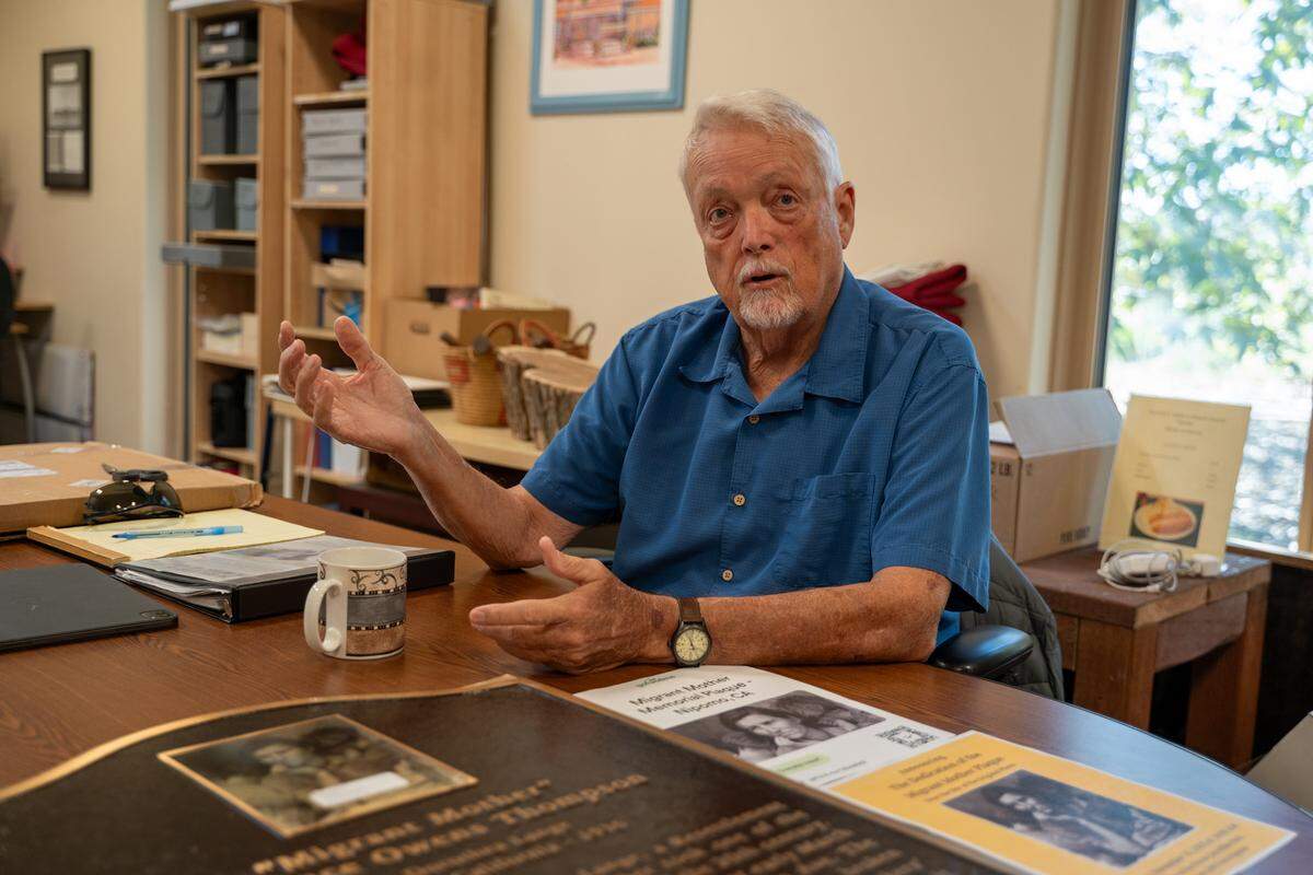 Former Judkins Middle School social studies teacher and Dana Adobe & Cultural Center docent Terry Handy sits with the 'Migrant Mother' plaque he commissioned on Friday, Oct. 24, 2025.