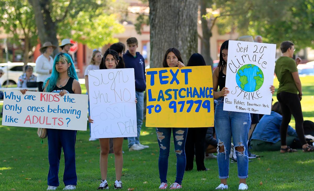 Paso Robles High School students, from left, Suzy Cano, 15, Brisa Estrada, 16, Nayeli Portillo, 16, and Jackie Delgado, 16, hold signs calling for action on climate change as part of the Global Climate Strike.