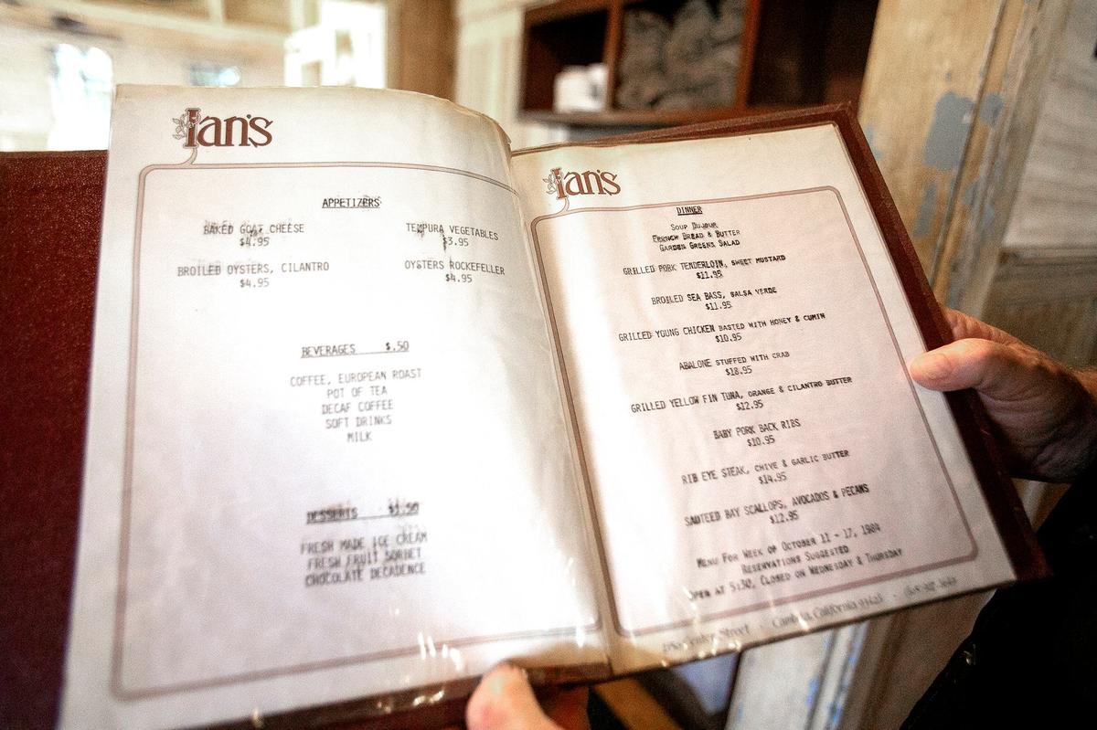 Ian McPhee, owner of McPhee’s Grill in Templeton, holds a menu from his first restaurant, Ian’s in Cambria.