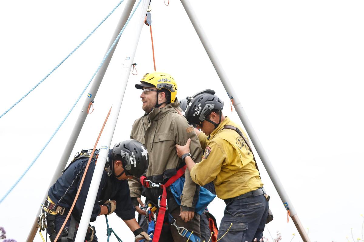Ryan McCormick of Shell Beach and his dog Rosie were hauled up from the bottom of a cliff at Dinosaur Caves after the golden retriever went over the side chasing an animal on June 29, 2023. SLO County firefighters unhook McCormick after lifting him to safety.