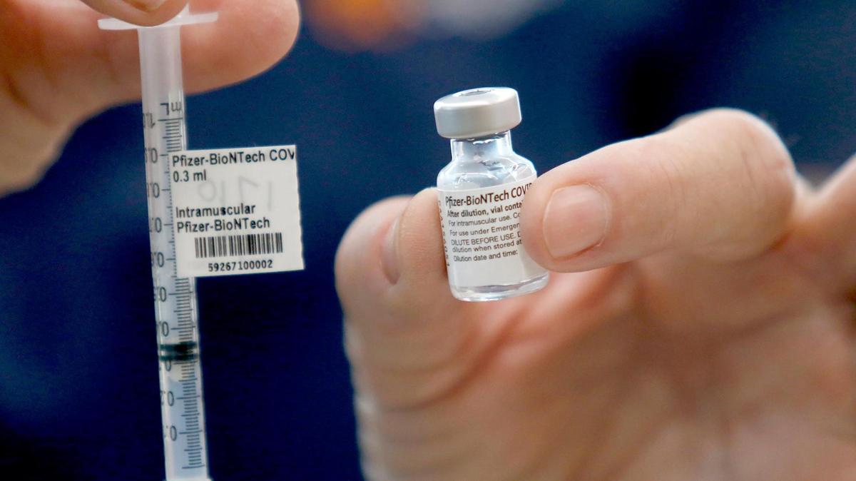 A health care worker holds a bottle and syringe of the Pfizer vaccine at French Hospital Medical Center’s COVID-19 vaccination clinic in San Luis Obispo.