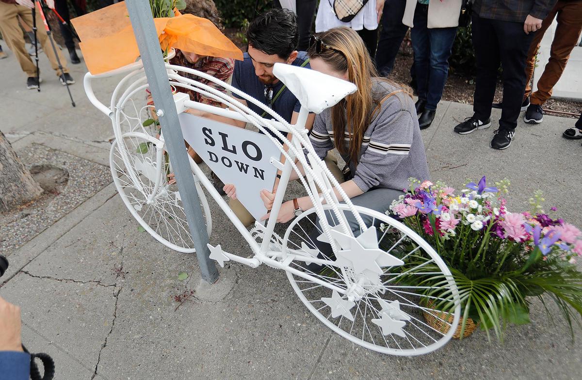 Andreas Kooi was a Cal Poly grad student who was hit by a drunk driver while he was biking on Foothill Blvd in 2021. His family is installied a “ghost bike” memorial near the scene of the accident, Saturday, Feb. 4, 2023. David Kooi and his wife Elizabeth, place a placard on the bicycle.
