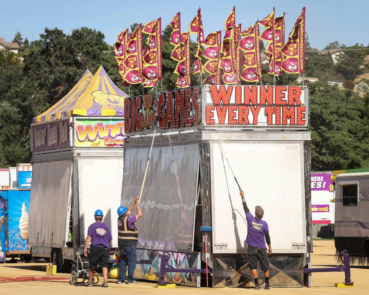 Crews clean travel dust as the the midway is set up by Helm and Sons Amusements on Monday, July 15, 2024, ahead of the California Mid-State Fair’s opening on Wednesday.