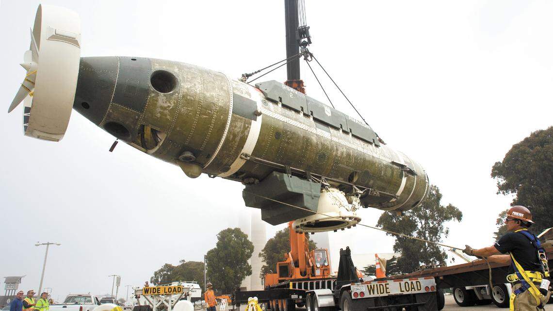 Paul Trombley holds a rope to prevent the sub from spinning as it’s lifted onto the display platform.