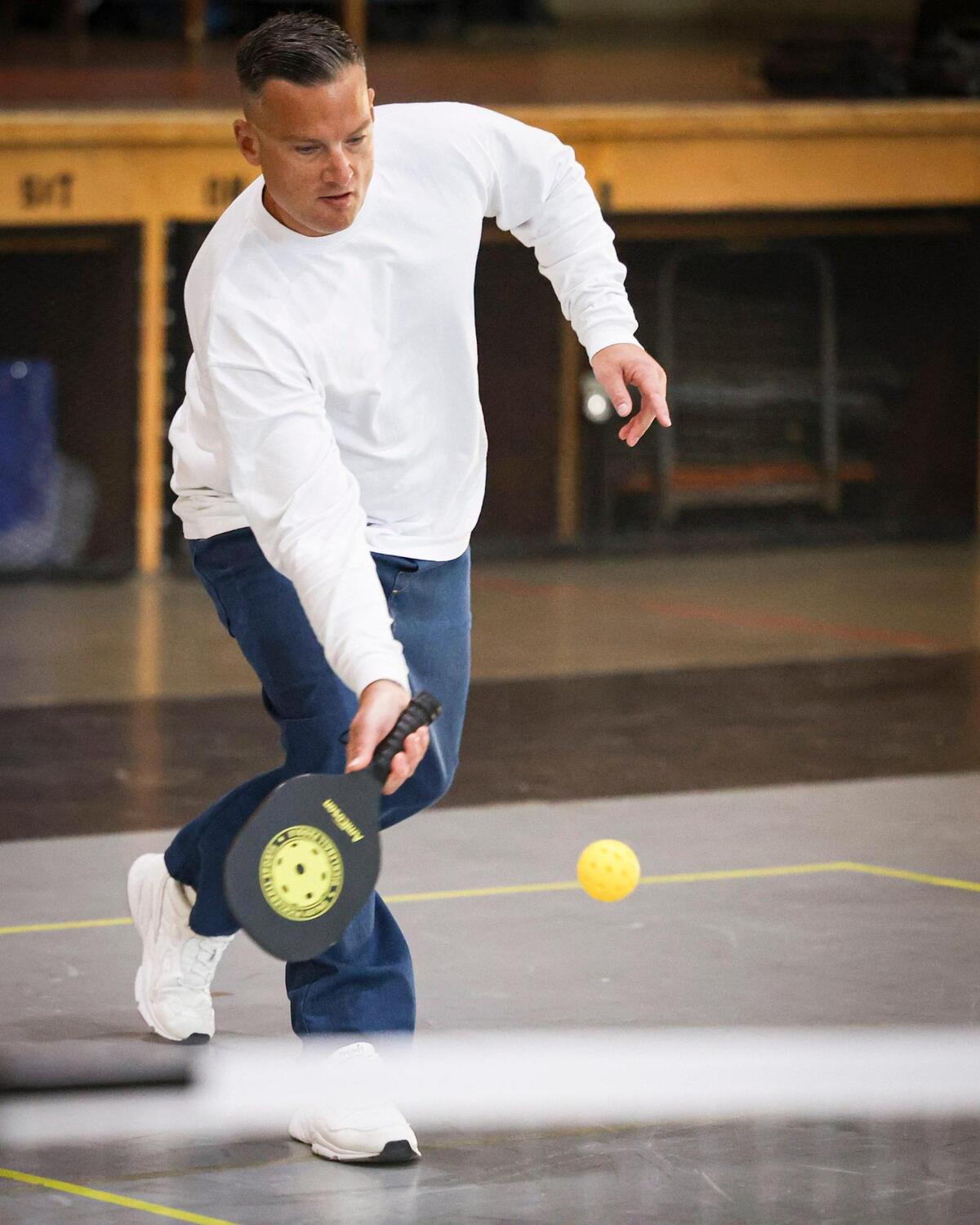California Men’s Colony inmate Jamie Willard hits pickleball on Nov. 12, 2024, as a film crew records how the sport can break down barriers and provide positive interactions between inmates and staff.