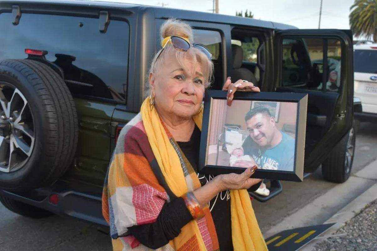 Lilly Denes holds a picture of her son, Rubiell Meza, with his new daughter, Melodee, shortly after the birth in 2016. One month later, Meza died in a motorcycle crash.
