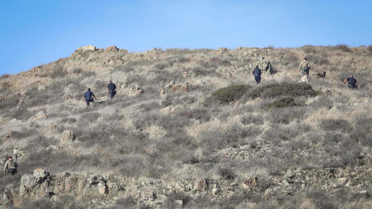 At least seven police officers and sheriff deputies searched the hillside behind Golden Gong on Madonna Road on Nov. 19, 2024, for a burglary suspect.