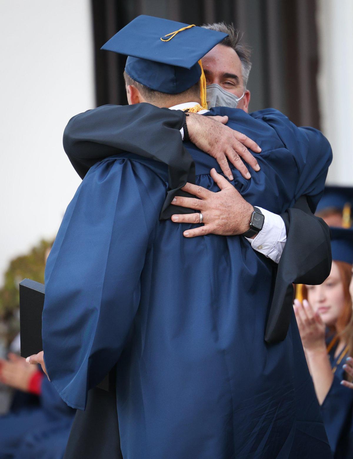 Jack Susank gets a hug from the principal and his father Jack after winning the Serra award. Mission College Preparatory Catholic High School graduated on the steps of Mission San Luis Obispo on June 3, 2022.
