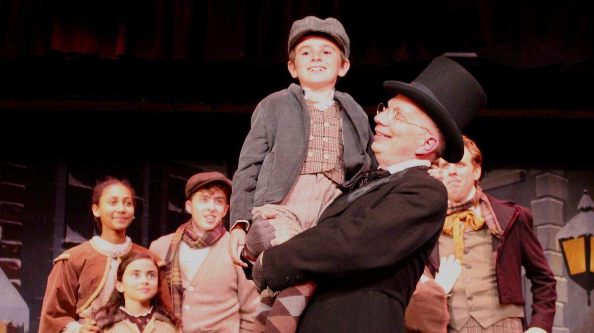 Ebenezer Scrooge (Billy Breed), center, lifts up Tiny Tim (Corbin Brown) in a scene from “A Christmas Carol,” which played in 2019 as part of “The Holiday Extravaganza” at the Great American Vaudeville & Melodrama in Oceano.