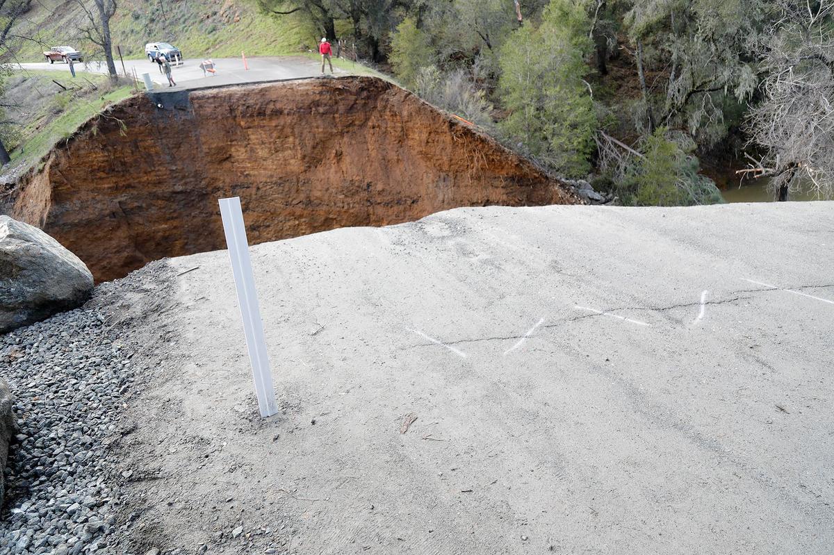 A man assesses the damage at Chimney Rock Road northwest of Paso Robles on Saturday, March 11, 2023. A section of the road washed out a recent rain storm to hit San Luis Obispo County, stranding at least 100 residents.