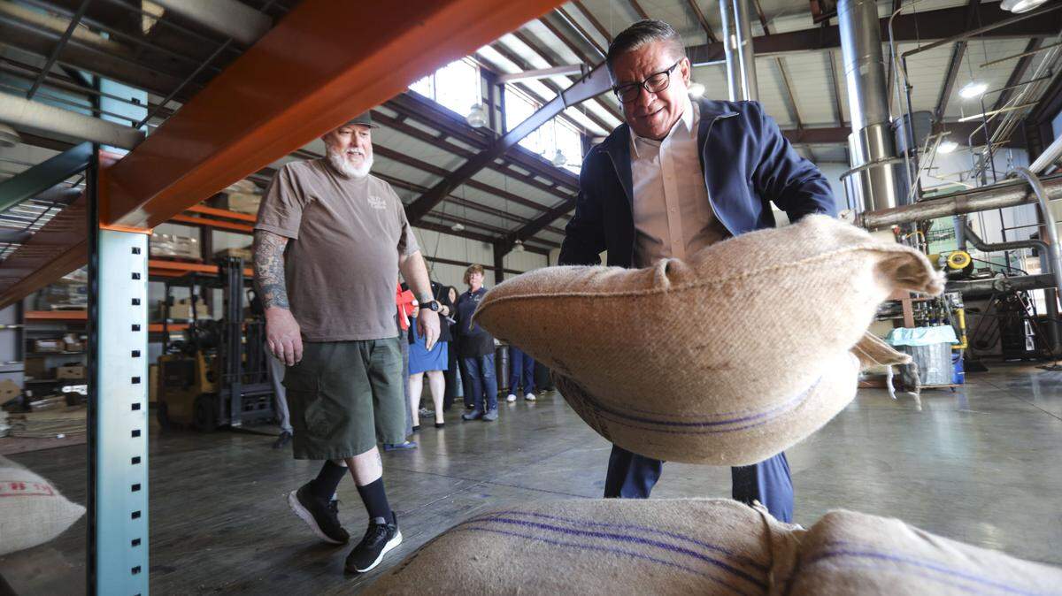 Rep. Salud Carbajal toured SLO Roasted Coffee and tried his hand at lifting a 60 kilo bag of coffee from Uganda. At left is Adam Boyd the lead coffe roaster on Jan. 16, 2026.