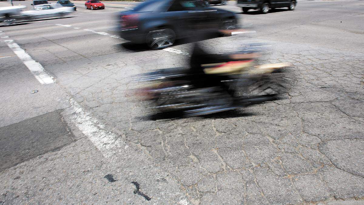 Traffic zips across battered asphalt at Niblick and South River roads, near Walmart. Lack of maintenence has resulted in worn striping and a surface fractured with cracks.