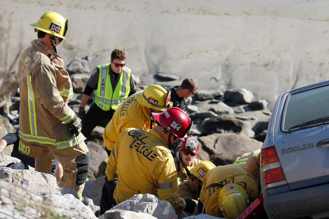 A Cal Fire extracation team helped to free a passenger in the Mercedes hatchback that went over the side of the Avila Beach Drive onto the rocks at Olde Port Beach on Jan. 1, 2025.