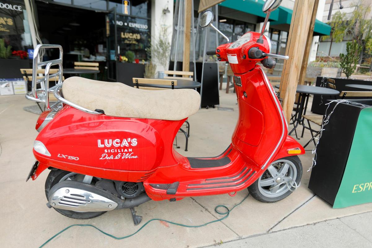 A red scooter is parked outside in front of Luca’s Sicilian Wine & Deli. The restaurant opens in Arroyo Grande with Sicilian dishes and family flair.