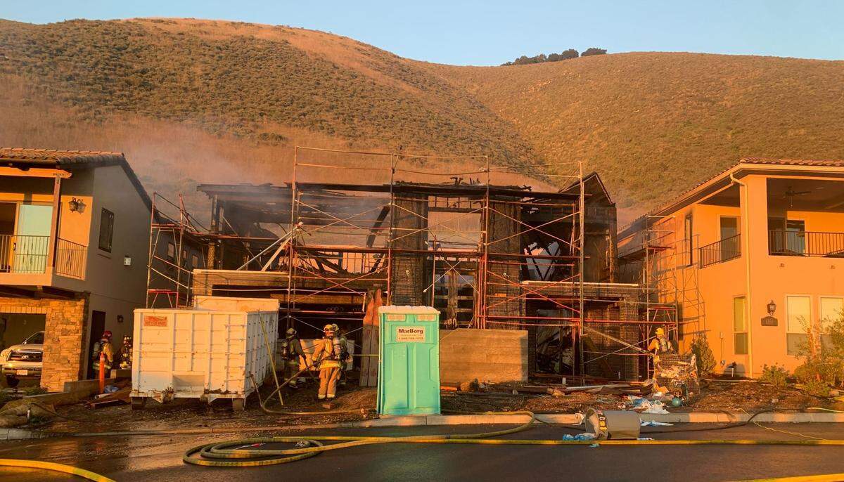 Firefighters work to extinguish a fire Tuesday afternoon at a new home under construction in the 1200 block of Costa Brava in Pismo Beach.