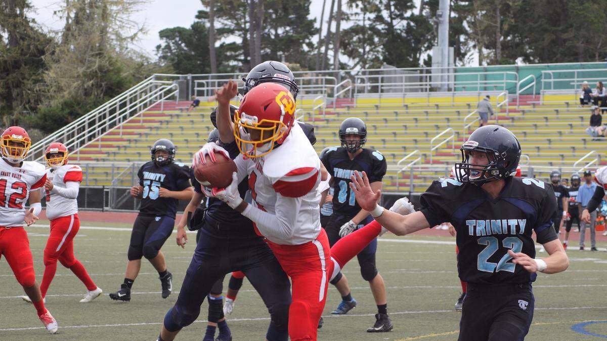 Coast Union High School quarterback Emany Plasencia scored four touchdowns and rushed for 134 yards Saturday, Sept. 7, against Trinity Christian in Monterey. Here, he battles for yardage on a quarterback keeper.  